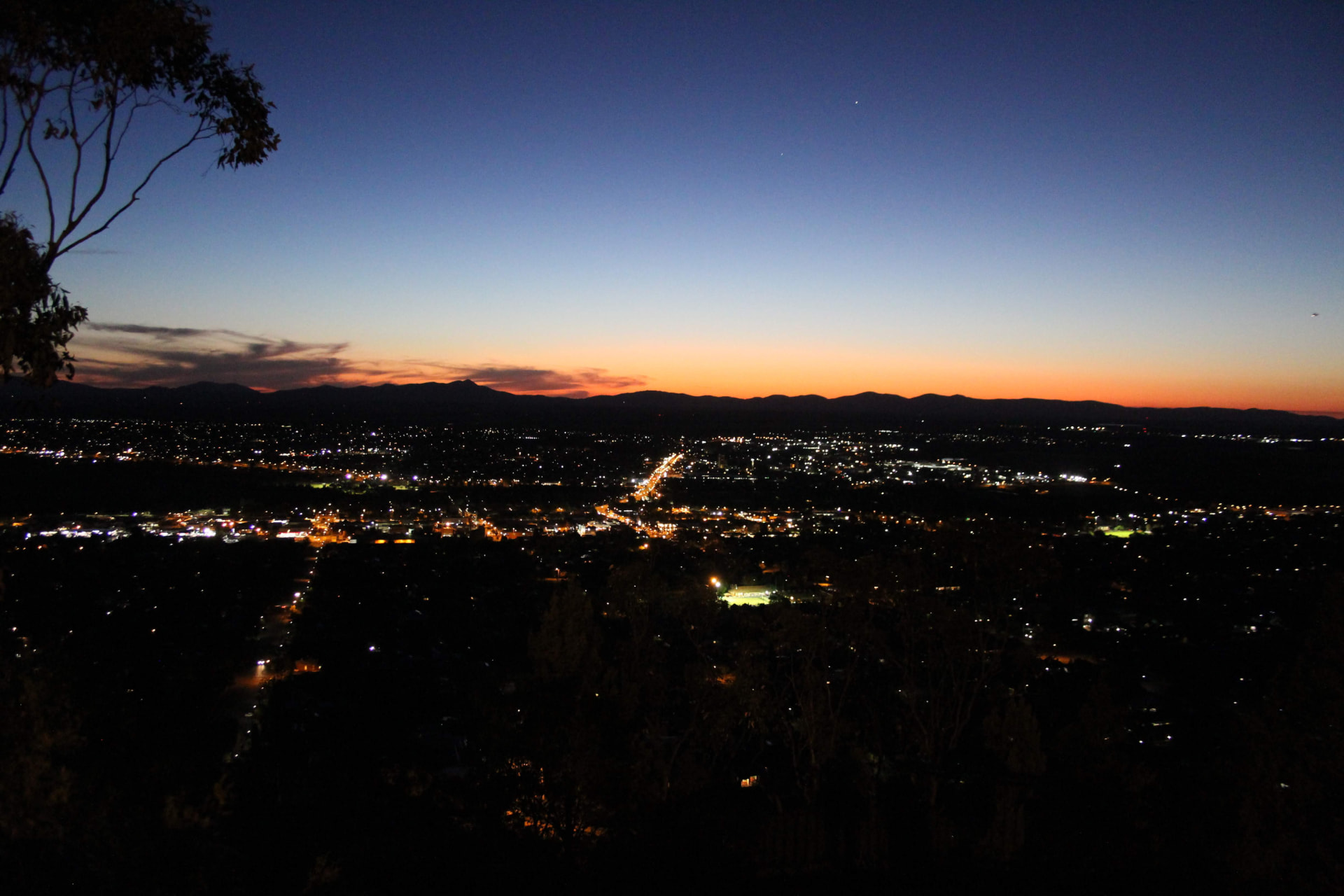 Tamworth at dusk seen from the lookout, city lights spread across the valley with the ranges beyond.