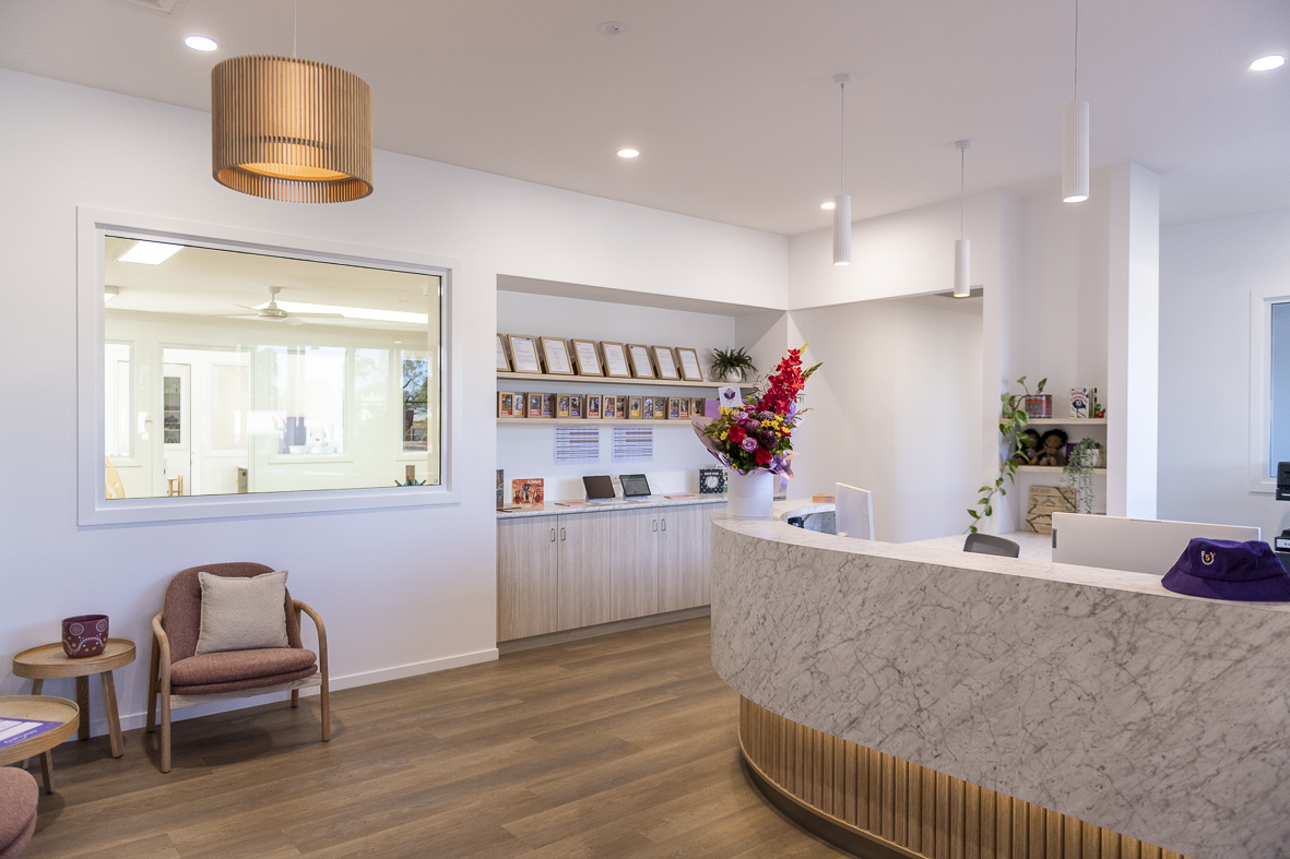 The reception area at First5Years Emerald, with timber joinery and a curved front desk.