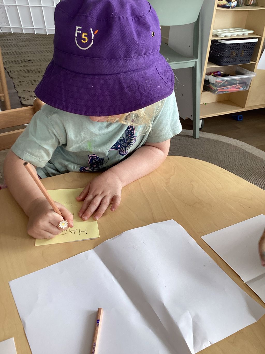 A child drawing at a table at First5Years Emerald.