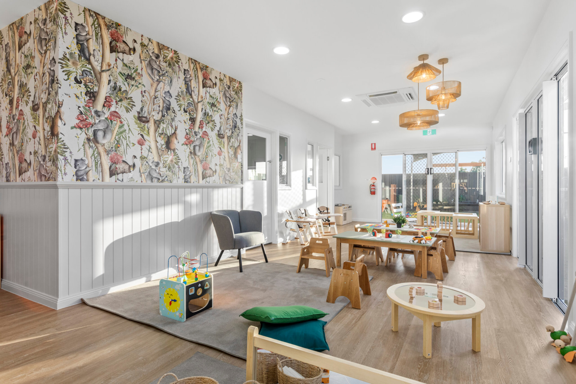 A First5Years Calliope learning room with a koala and gum-blossom mural, timber furniture and natural light.