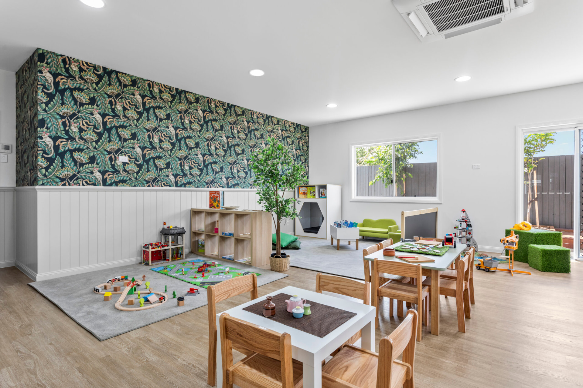 A First5Years Calliope room with a dark botanical wall, timber shelving and a quiet reading nook.