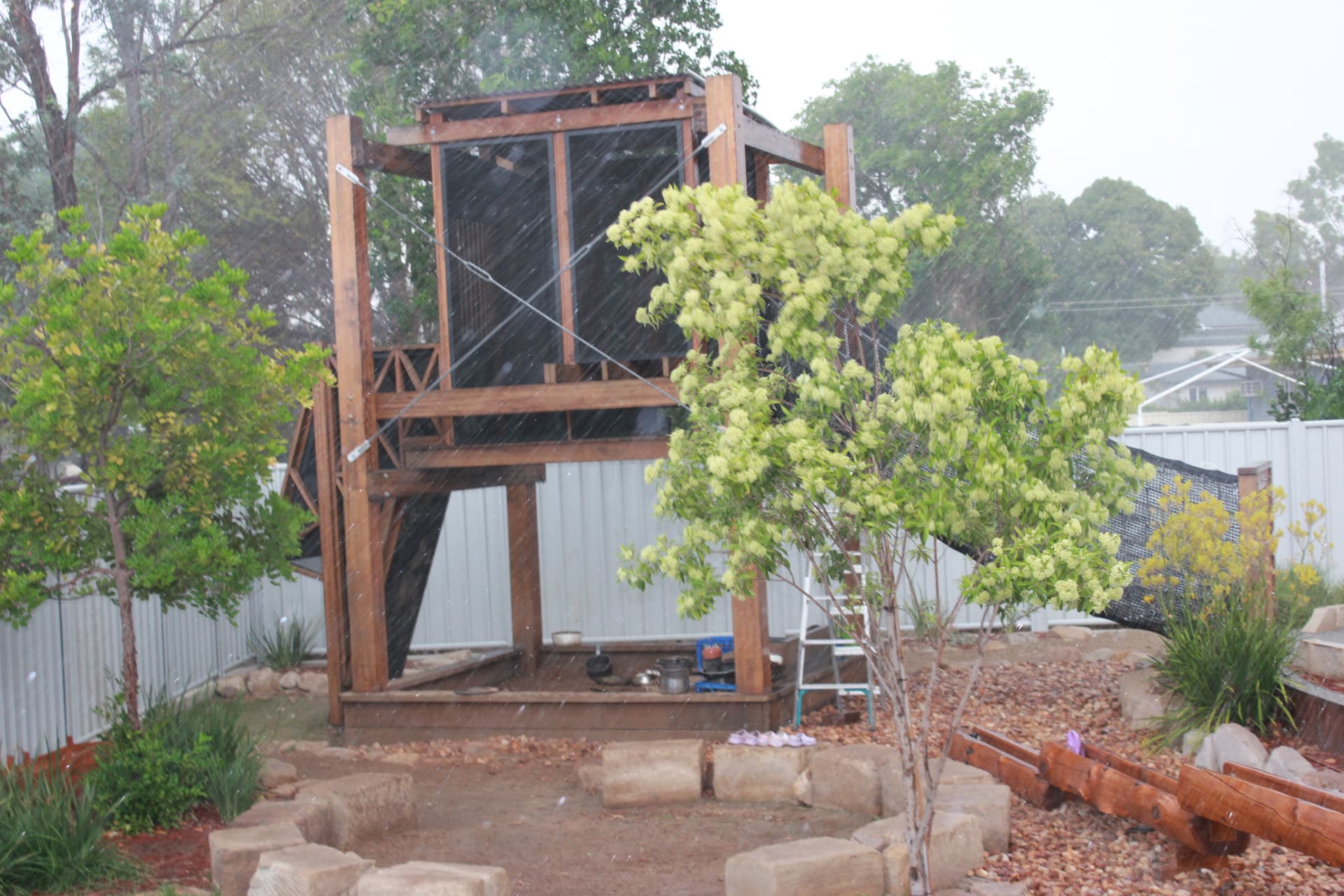 Children playing in the rain at the Mineshaft Fort in the First5Years Emerald playscape.
