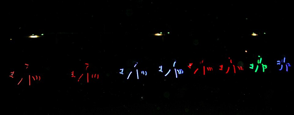 Riders and horses outlined in coloured light during a night performance at the Australian Equine and Livestock Events Centre, Tamworth.
