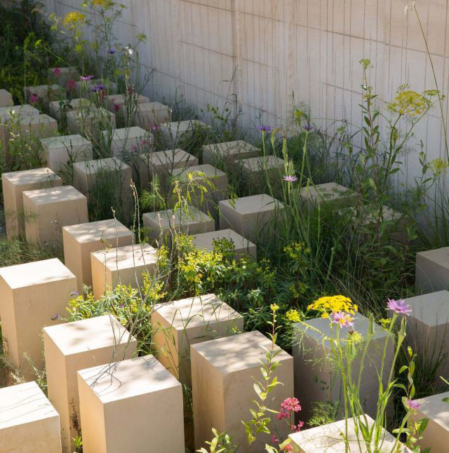 Reference image: a grid of stone plinths set among wildflowers and grasses.