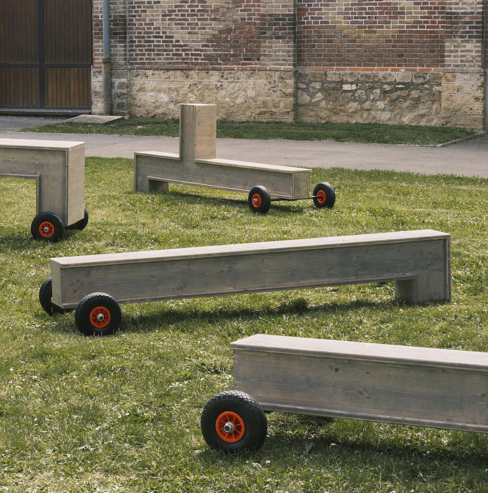 Reference image: mobile timber benches on wheels on a lawn.