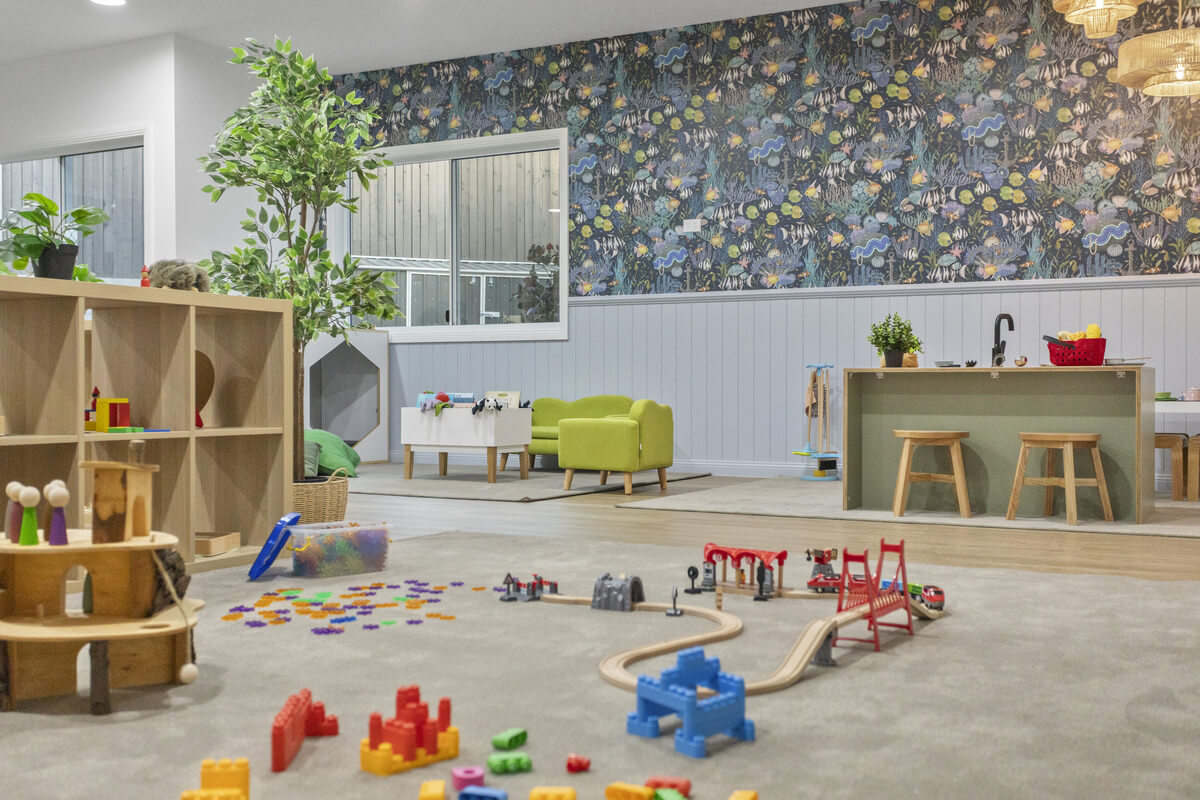 A First5Years Calliope playroom with botanical wallpaper, timber shelving and open-ended materials.